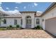 Elegant front entrance with a paver walkway and meticulously landscaped garden beds at 16304 Wild Mallard Dr, Odessa, FL 33556