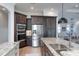 Gourmet kitchen features granite countertops, stainless appliances, and dark wood cabinets at 16304 Wild Mallard Dr, Odessa, FL 33556