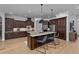 Spacious kitchen features dark wood cabinets, a large island with seating, and stainless steel appliances at 16304 Wild Mallard Dr, Odessa, FL 33556