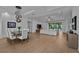 Open-concept living and dining area features modern lighting, wood floors, and access to the outdoor space at 16304 Wild Mallard Dr, Odessa, FL 33556