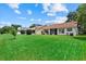 Expansive backyard featuring a lush lawn, mature trees, and a screened-in patio, perfect for outdoor entertaining at 1741 Elk Spring Dr, Brandon, FL 33511