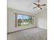 Bedroom with neutral carpet, large window offering pleasant views, and ceiling fan at 1741 Elk Spring Dr, Brandon, FL 33511