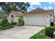 Charming home featuring a two-car garage, manicured landscaping, and a welcoming facade with a large window at 1741 Elk Spring Dr, Brandon, FL 33511