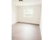 A bright, empty bedroom with neutral walls and modern flooring, bathed in natural light from a window at 2328 Harn Blvd, Clearwater, FL 33764