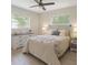 A cozy bedroom features two windows, a ceiling fan, a bed, a dresser, and matching nightstands at 2328 Harn Blvd, Clearwater, FL 33764