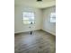 A bright, empty bedroom with two windows and modern flooring, bathed in natural light at 2328 Harn Blvd, Clearwater, FL 33764