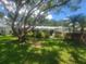 Charming one-story home featuring a well-manicured lawn, mature shade tree, and lush landscaping at 2328 Harn Blvd, Clearwater, FL 33764