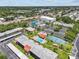 Community aerial view showcasing lush landscaping, pool, and tennis courts centrally located near retail at 2420 Winding Creek Blvd # 209, Clearwater, FL 33761