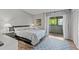 Cozy bedroom featuring a queen-sized bed, soft rug, and sliding glass doors to the balcony at 2420 Winding Creek Blvd # 209, Clearwater, FL 33761