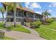Condominium exterior with green grass, landscaping, and staircase to unit at 2420 Winding Creek Blvd # 209, Clearwater, FL 33761