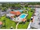 Aerial view of a sparkling community pool and tennis court with lush landscaping and inviting lounge area at 2420 Winding Creek Blvd # 209, Clearwater, FL 33761