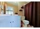 Bright bathroom featuring a vanity with storage, toilet, and shower with decorative brown curtain at 2898 Thaxton Dr # 76, Palm Harbor, FL 34684