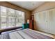 Bedroom with a window, ceiling fan, a striped bedspread, and closet space for storage at 2898 Thaxton Dr # 76, Palm Harbor, FL 34684