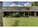 Backyard of home with screen doors and garden, with lawn leading up to the house at 2898 Thaxton Dr # 76, Palm Harbor, FL 34684