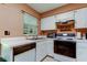 White kitchen cabinets and appliances, double sink under a window at 2898 Thaxton Dr # 76, Palm Harbor, FL 34684