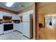 Kitchen with white cabinets, appliances, and tile flooring, hallway entrance in the background at 2898 Thaxton Dr # 76, Palm Harbor, FL 34684
