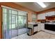 Kitchen with a sliding door leading to a screened-in porch, white cabinets, appliances, and tile flooring at 2898 Thaxton Dr # 76, Palm Harbor, FL 34684