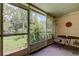 Enclosed porch with seating area and screen windows showcasing landscaping and outdoor views at 2898 Thaxton Dr # 76, Palm Harbor, FL 34684