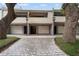 Charming townhouse exterior featuring a private garage and a welcoming entrance amidst lush greenery at 301 2Nd N St # 14, St Petersburg, FL 33701