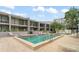 Community pool surrounded by lounge chairs, mature trees, and lush landscaping at 301 2Nd N St # 14, St Petersburg, FL 33701