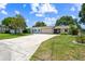 Charming single story home with a wide driveway, lush lawn, and a two-car garage at 336 Westwinds Cir, Palm Harbor, FL 34683
