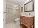 Bathroom featuring granite countertops, stylish vanity, and a frameless glass shower with tile surround at 3368 Ramblewood Pl # 37-D-1, Sarasota, FL 34237