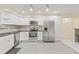 Modern kitchen with stainless steel appliances, mosaic backsplash, and white cabinetry at 3368 Ramblewood Pl # 37-D-1, Sarasota, FL 34237