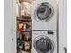 This laundry room features a stacked washer and dryer unit and a convenient shelving unit for supplies at 3368 Ramblewood Pl # 37-D-1, Sarasota, FL 34237