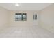 Bright living room with white tile flooring, neutral walls, a window, and an exterior door at 3368 Ramblewood Pl # 37-D-1, Sarasota, FL 34237