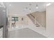 Open living area with tile flooring, staircase, and stainless steel refrigerator at 3368 Ramblewood Pl # 37-D-1, Sarasota, FL 34237