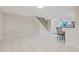 Open living space with white tile, a staircase, and a view of the kitchen with barstool seating at 3368 Ramblewood Pl # 37-D-1, Sarasota, FL 34237