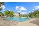Community pool surrounded by lounge chairs on a sunny day with clear blue skies and green trees at 3368 Ramblewood Pl # 37-D-1, Sarasota, FL 34237