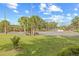 Fenced tennis court features well maintained court, palm trees, and grassy area at 3368 Ramblewood Pl # 37-D-1, Sarasota, FL 34237