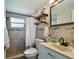 Bathroom featuring tiled shower, neutral walls, with stone floor, plus updated vanity and mirror at 3427 Cantrell St, Holiday, FL 34690