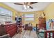 A bright Bedroom with two cribs, wood-look floors, and yellow walls, creating a cheerful space at 3427 Cantrell St, Holiday, FL 34690