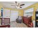 A Bedroom featuring wood-look floors, a rocking chair, and a crib, offering a tranquil setting at 3427 Cantrell St, Holiday, FL 34690