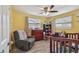 A cozy Bedroom featuring a gray rocking chair, wood-look floors, and sunny yellow walls at 3427 Cantrell St, Holiday, FL 34690