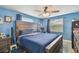 Cozy bedroom with a wooden bed frame, ceiling fan, and two windows providing ample natural light at 3427 Cantrell St, Holiday, FL 34690