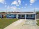 Comfortable single-story home with solar panels, a green lawn and a covered front porch, with a blue exterior at 3427 Cantrell St, Holiday, FL 34690