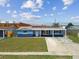 Well-kept single-story home with solar panels, blue paint, a well-maintained lawn and a covered front porch at 3427 Cantrell St, Holiday, FL 34690