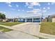 Charming single-story home with solar panels, a green lawn and a covered front porch, boasting a blue exterior at 3427 Cantrell St, Holiday, FL 34690