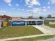 Charming single-story home with solar panels, a green lawn and a covered front porch, boasting a blue exterior at 3427 Cantrell St, Holiday, FL 34690