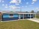 Comfortable single-story home with a green lawn and a covered front porch, boasting a blue exterior at 3427 Cantrell St, Holiday, FL 34690