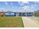 Charming single-story home featuring a covered entrance, updated paint, manicured lawn, and a spacious driveway at 3427 Cantrell St, Holiday, FL 34690