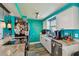 Efficient kitchen featuring granite countertops, stainless steel appliances, white cabinetry, and vibrant teal walls at 3427 Cantrell St, Holiday, FL 34690
