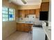 A kitchen features wood cabinets, a white appliance, and natural light from the window at 3518 16Th S Ave, St Petersburg, FL 33711
