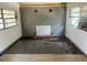 Empty living room with two windows, damaged flooring, and a non-functioning fireplace at 3518 16Th S Ave, St Petersburg, FL 33711