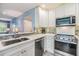 Bright kitchen featuring stainless steel appliances, modern countertops, and sleek white cabinetry at 387 S Mcmullen Booth Rd # 16, Clearwater, FL 33759