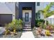 Inviting front entrance with modern black door, well maintained landscaping, and lovely pavers at 4604 W Euclid Ave, Tampa, FL 33629