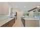 Gourmet kitchen boasts stainless steel appliances, custom cabinets, and center island with stone countertop at 4604 W Euclid Ave, Tampa, FL 33629